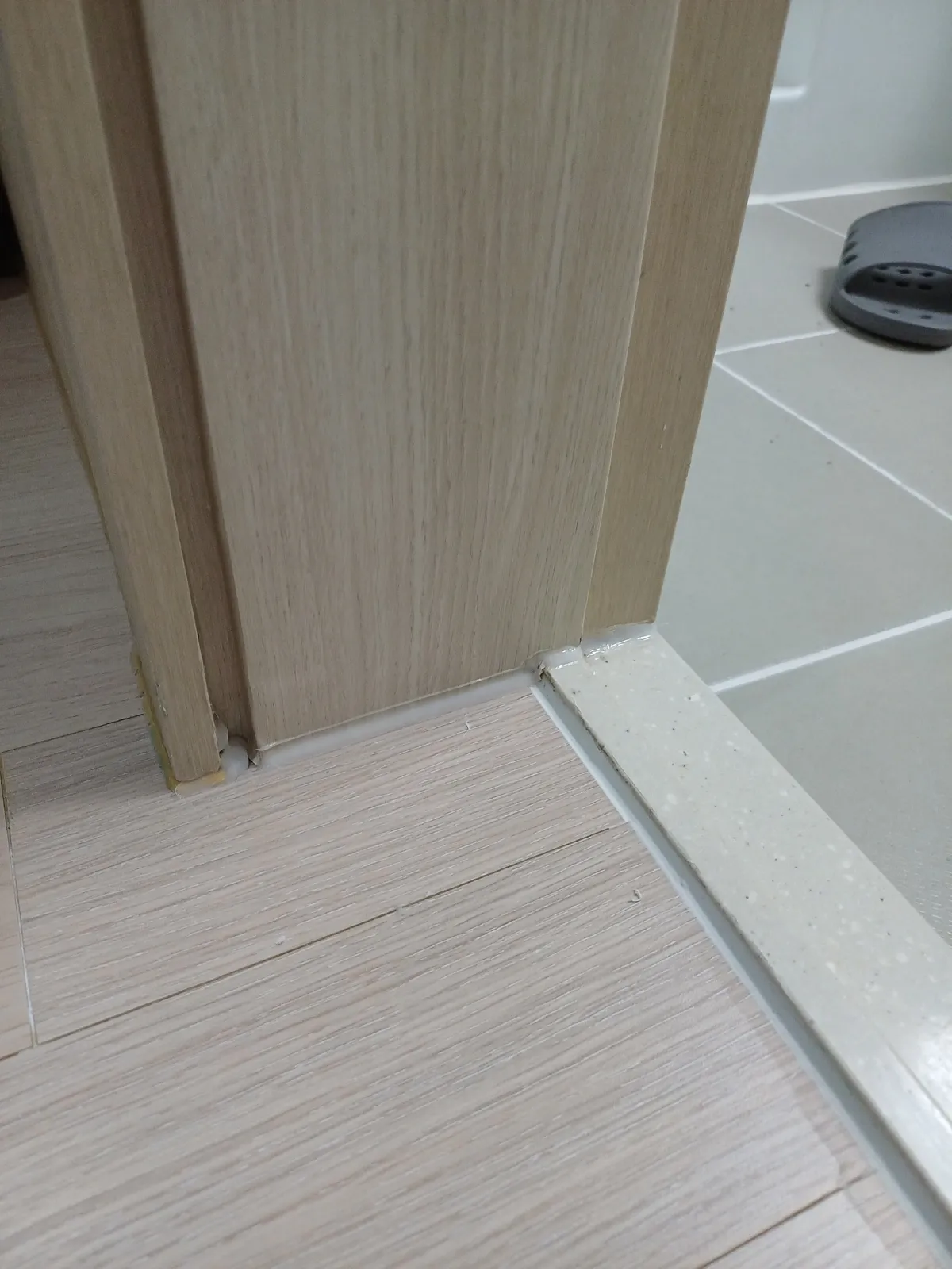 안양 화장실 문틀 하단이 보수 후 타일 문턱 옆에서 깔끔하게 정리된 모습